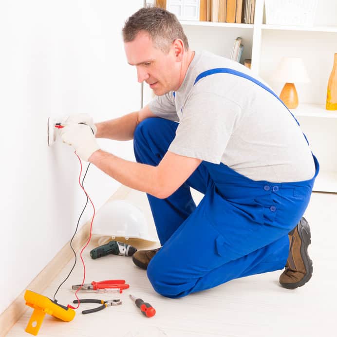 Electrician Checking Socket Voltage With Digital Multimeter