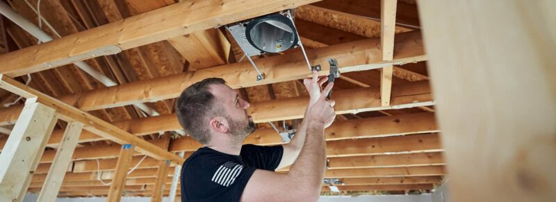 residential electrician installing ceiling light